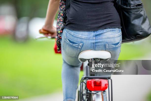 公共公園で自転車に乗っている若い女性の背面図 - bottom up ストックフォトと画像