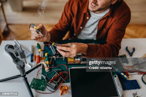 young man vlogging while repairing laptop at home - filming tutorial stock pictures, royalty-free photos & images