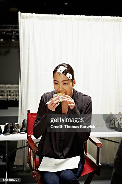 model sitting backstage at fashion show eating - model backstage stock pictures, royalty-free photos & images