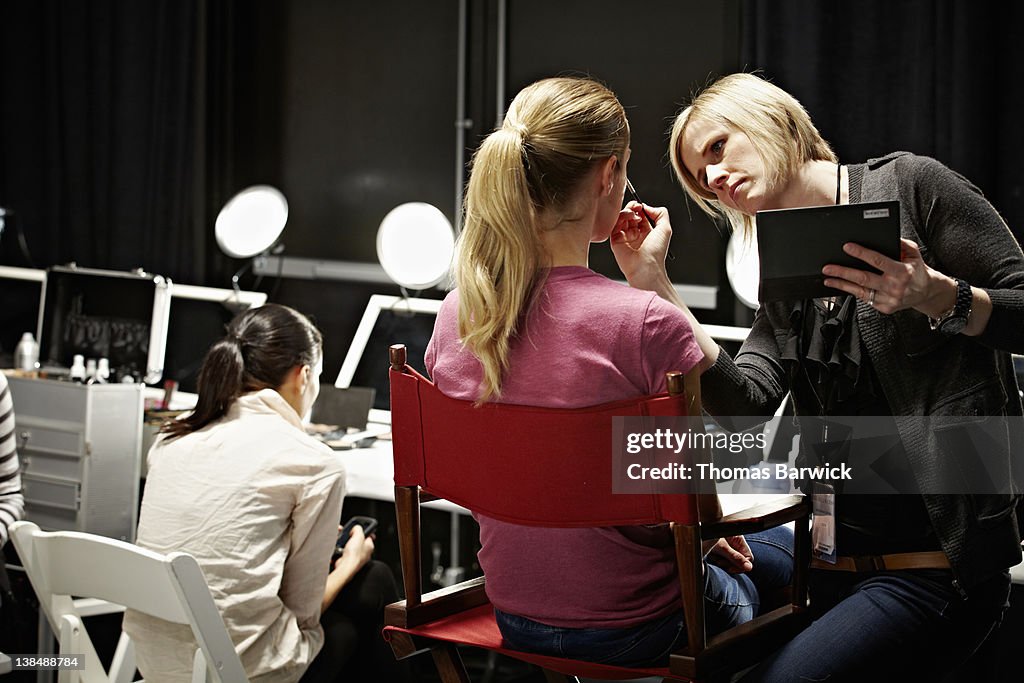 Make-up artist and model backstage at fashion show