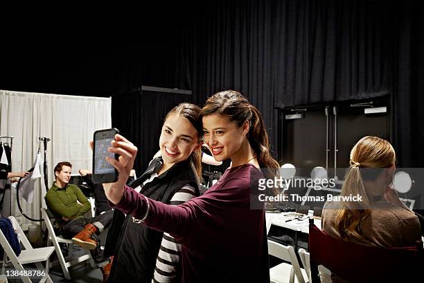 two models backstage at fashion show taking photo - modenschau stock-fotos und bilder