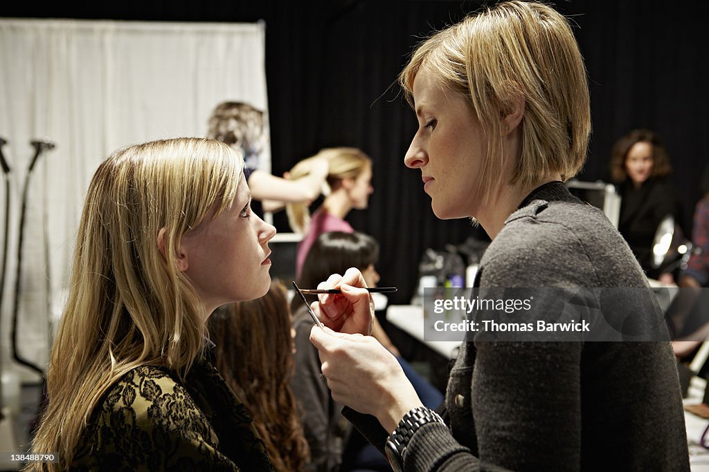 Model backstage at fashion show in make-up