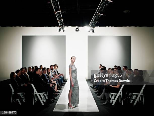 model in gown posing at end of catwalk - diversity showcase arrivals stock pictures, royalty-free photos & images