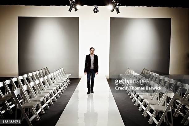 young fashion designer standing on empty catwalk - stage performance space stock pictures, royalty-free photos & images