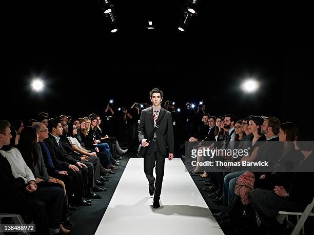 cool geek walking down runway at fashion show - fashion show stock-fotos und bilder