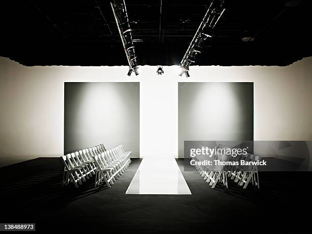 chairs around catwalk set for fashion show - podium de défilé photos et images de collection