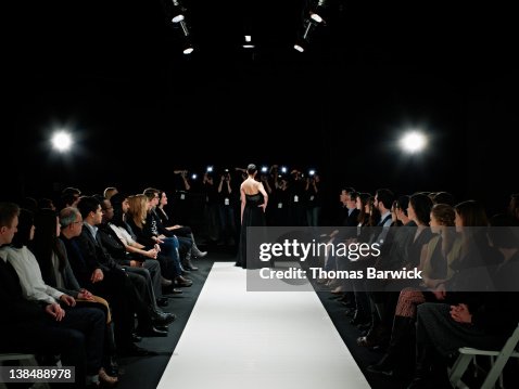 Model in gown at end of catwalk posing Model in gown at end of catwalk posing