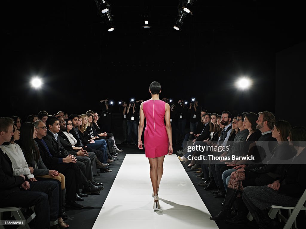 Model walking on catwalk in fashion show