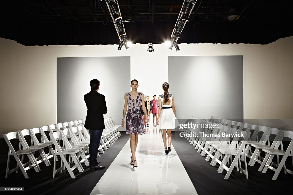Designer watching models practice for fashion show