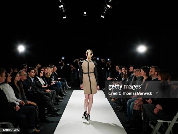 model walking down catwalk during fashion show - fashion show ramp stock pictures, royalty-free photos & images