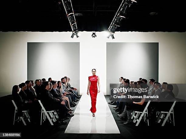 model in gown walking down catwalk at fashion show - semana de la moda fotografías e imágenes de stock