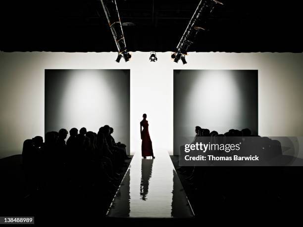 silhouette of female model on catwalk - catwalk fashion stock pictures, royalty-free photos & images