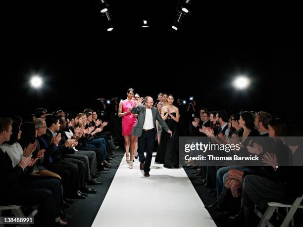 designer and models walking down catwalk - fashion show foto e immagini stock