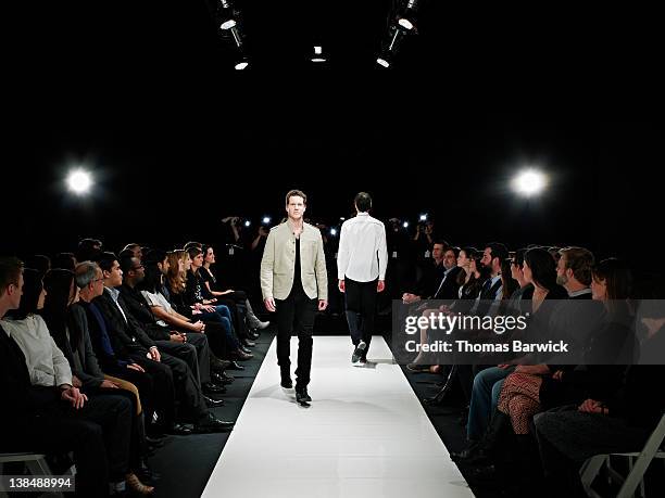 two male models walking on catwalk - male model stock-fotos und bilder