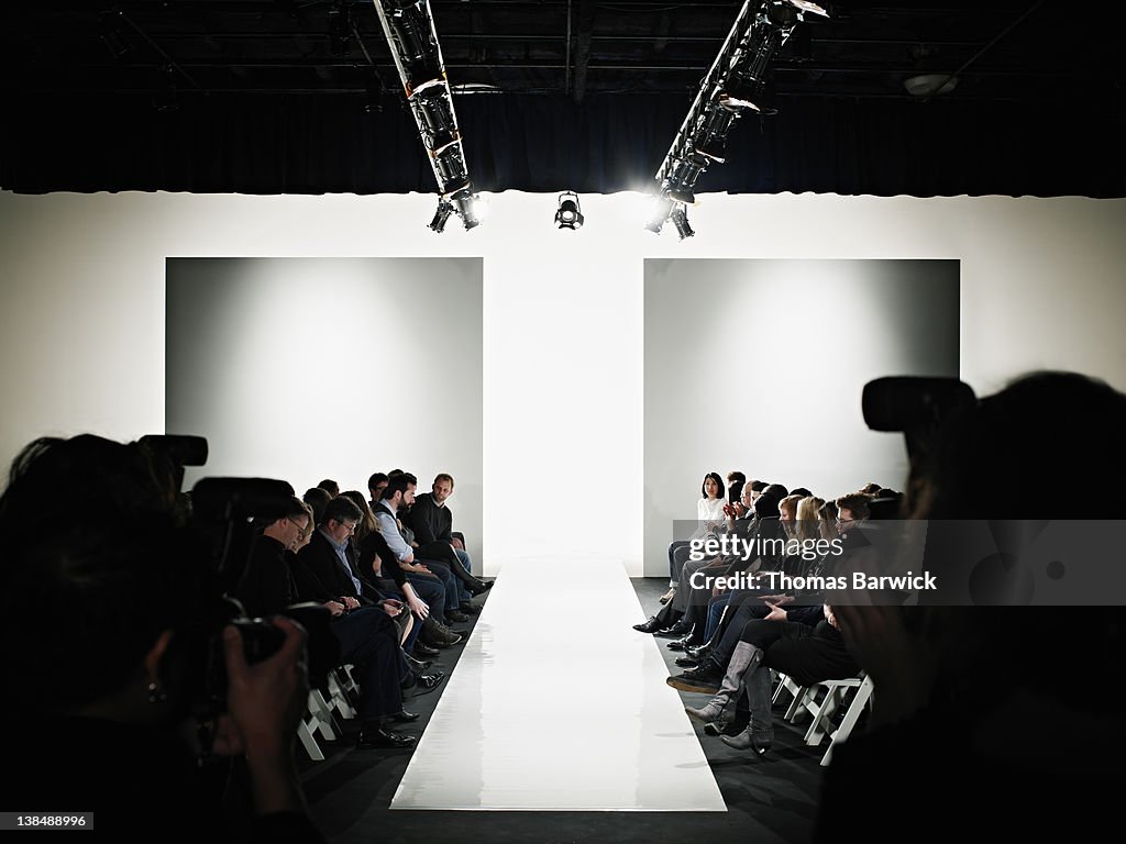 View down catwalk of photographers and crowd