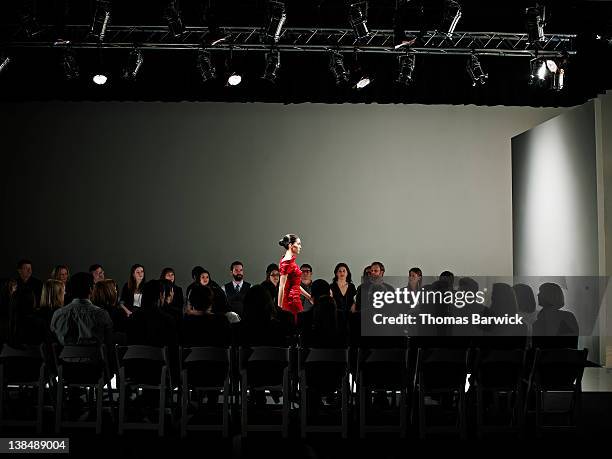 female model walking alone on catwalk - semana de la moda fotografías e imágenes de stock