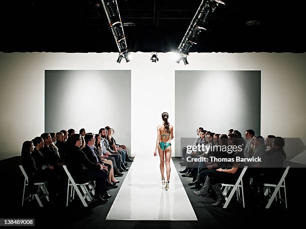 model in swimsuit walking down catwalk - walking runway stock pictures, royalty-free photos & images