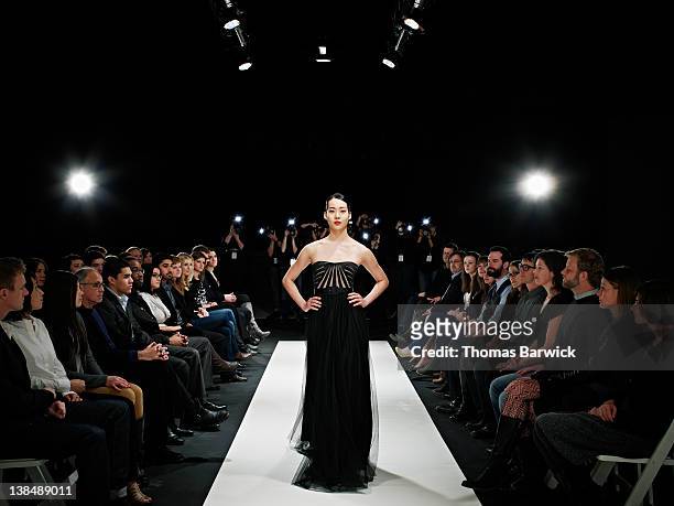 model in gown walking down catwalk - fashion show foto e immagini stock