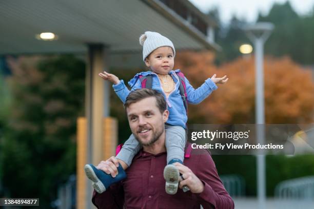 papa geht tochter von der schule nach hause - eltern baby hochheben stock-fotos und bilder