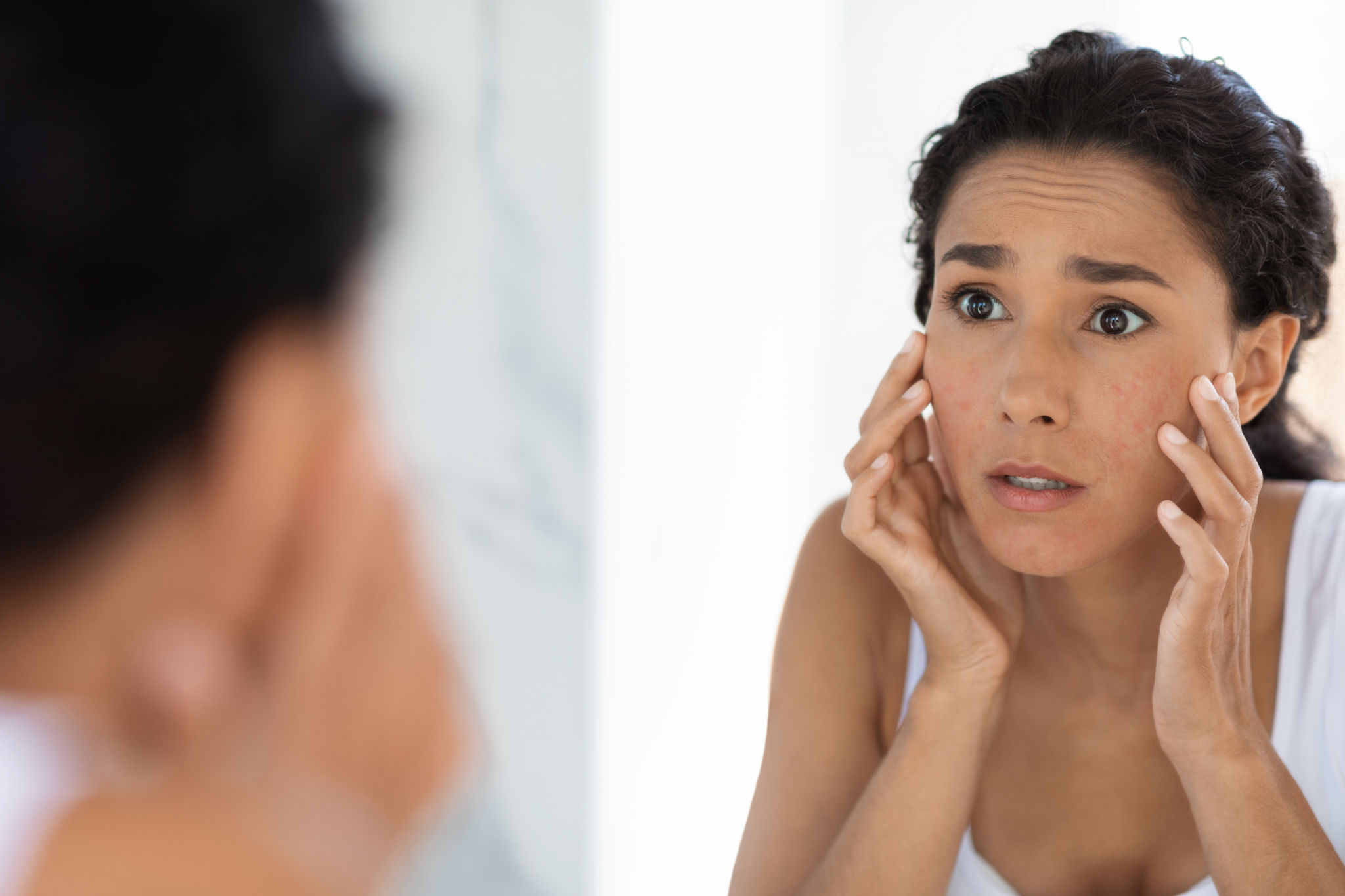 Atopic Skin Concept. Worried Young Woman Looking At Mirror And Touching Face Atopic Skin Concept. Worried Young Woman Looking At Mirror And Touching Face