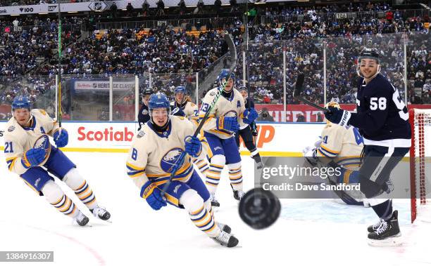 Kyle Okposo and Robert Hagg of the Buffalo Sabres and Michael Bunting of the Toronto Maple Leafs look to the puck in the corner during the second...