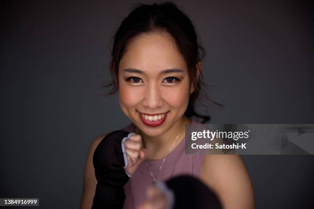 young female boxer standing against black background - fighting stance stock pictures, royalty-free photos & images