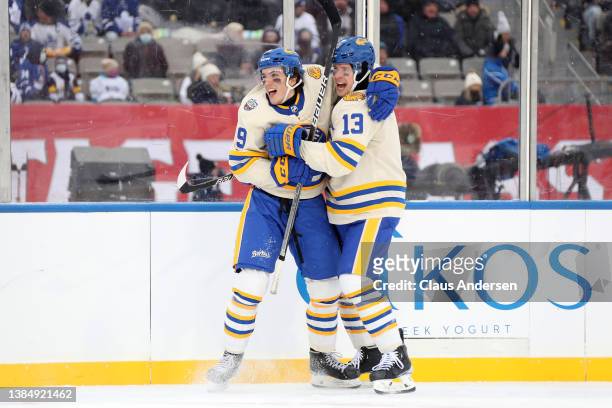 Peyton Krebs and Mark Pysyk of the Buffalo Sabres celebrate a goal against the Toronto Maple Leafs in the second period during the Heritage Classic...