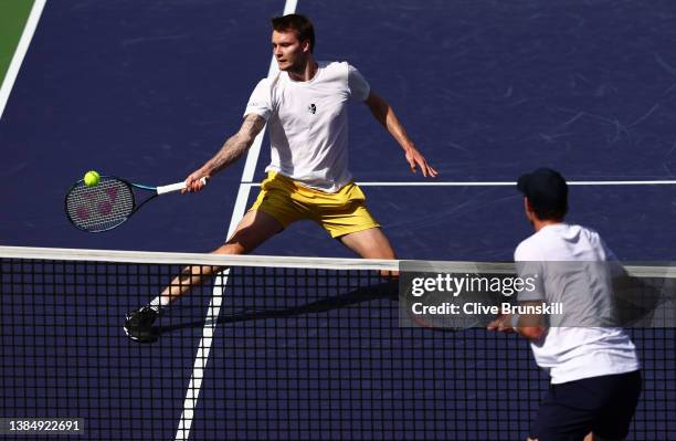 Alexander Bublik of Kazakhstan plays a forehand volley watched by opponent Andy Murray of Great Britain in their second round match on Day 7 of the...