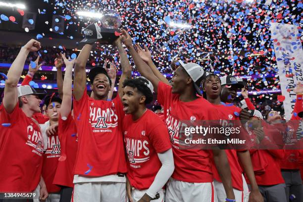 Dalen Terry of the Arizona Wildcats holds up the championship trophy as he celebrates with teammates Justin Kier, Bennedict Mathurin, Adama Bal and...