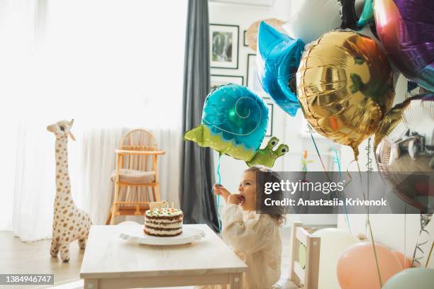 young girl blowing candles for celebreating her 2th years birthday. - 2 3 years stockfoto's en -beelden