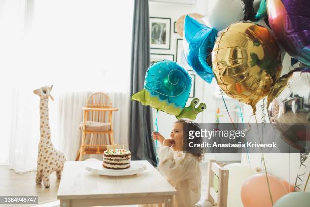 young girl blowing candles for celebreating her 2th years birthday. - 2 3 years stock pictures, royalty-free photos & images