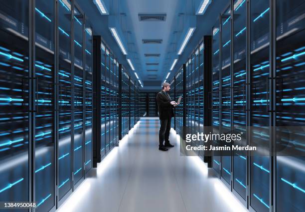man working on laptop in server room - cybersecurity stock-fotos und bilder