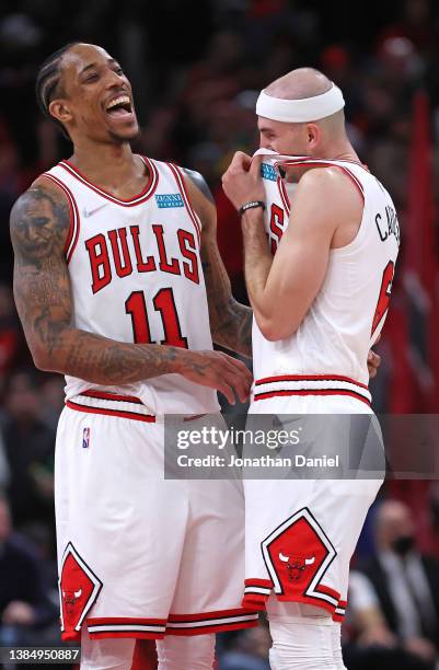 DeMar DeRozan and Alex Caruso of the Chicago Bulls share a laugh after a win against the Cleveland Cavaliers at the United Center on March 12, 2022...