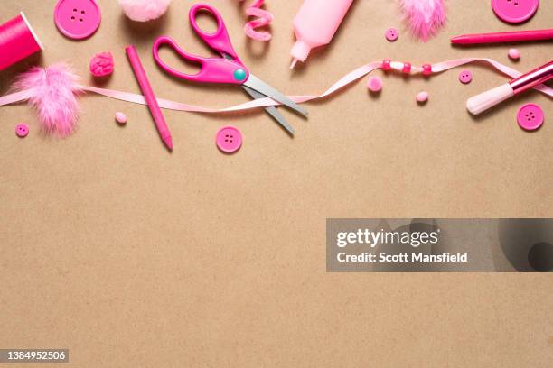 brown kraft paper background with top border of fun, all pink art and craft supplies - ribbon sewing item stock pictures, royalty-free photos & images