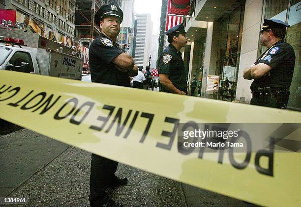 Officers keep watch outside an office building near Times Square where three people were killed in a shooting September 16, 2002 in New York City....