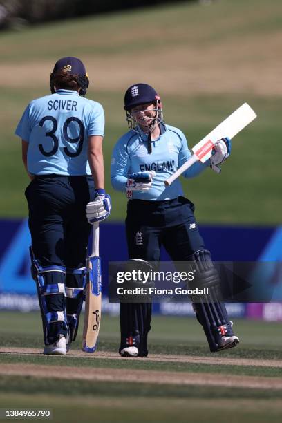 Tamsin Beaumont of England celebrates a boundary with Natalie Sciver of England during the 2022 ICC Women's Cricket World Cup match between South...