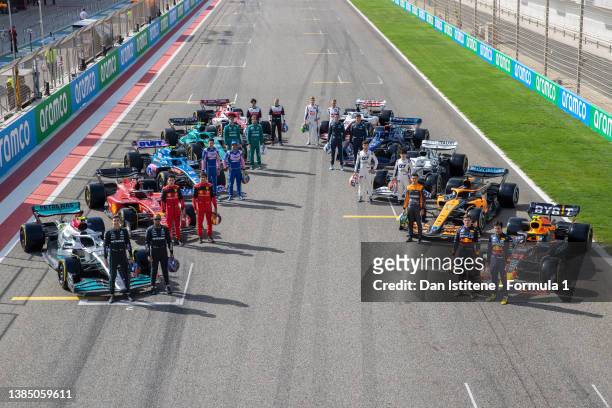 The F1 drivers pose for a photo on the grid with their cars during Day One of F1 Testing at Bahrain International Circuit on March 10, 2022 in...