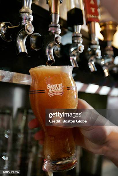 Bartender Pete Burton pours a pint of Samuel Adams lager into a new beer glass designed specifically for their lager at the Sunset Bar in the Allston...