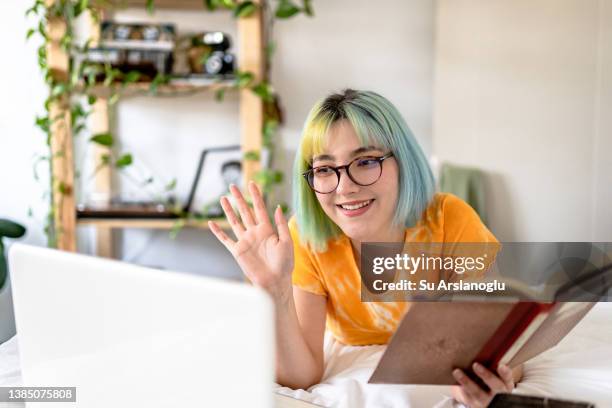 young woman with colored hair joins online book group - book club meeting stock pictures, royalty-free photos & images