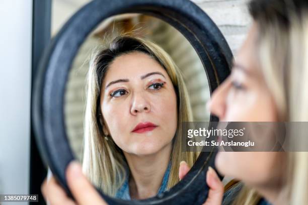 woman having eyelid surgery applies eye cream at home - psoriasis stock pictures, royalty-free photos & images
