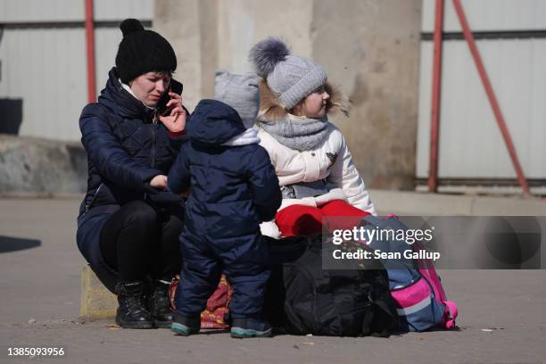 Mother and her two children who fled the region close to the site of yesterday's Russian cruise missile attack near Yavoriv in western Ukraine wait...