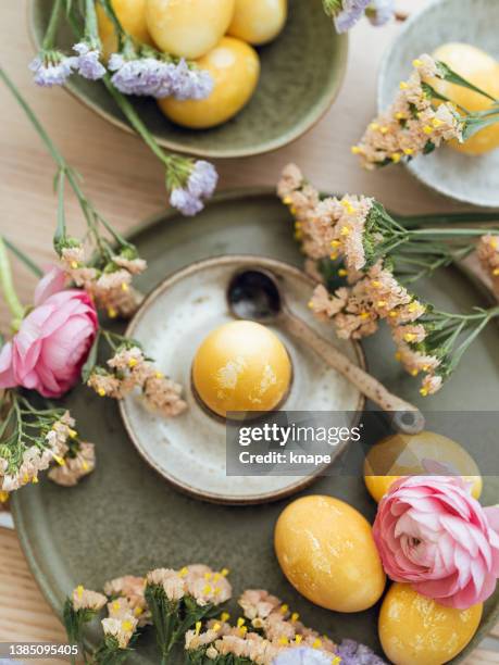 yellow natural colored easter egg and flowers arrangement - pasen stockfoto's en -beelden