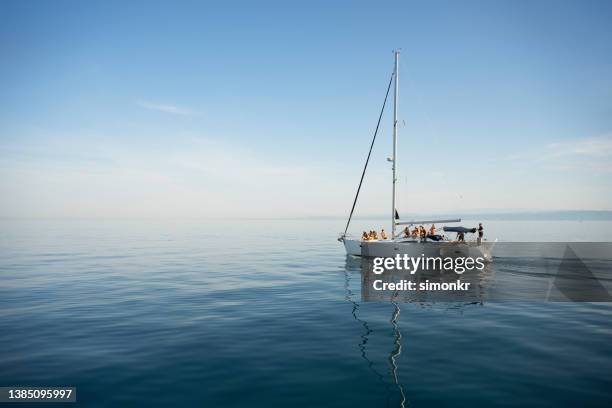 amigos sentados en velero - sailboat fotografías e imágenes de stock