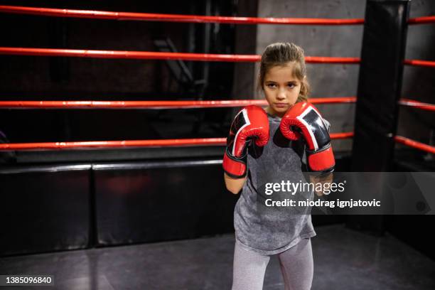 little girl in fighting stance in the boxing ring - boxing ring stock pictures, royalty-free photos & images