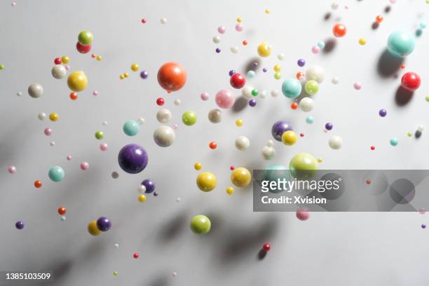 colorful sugar balls flying in mid air in white background - group 1 stockfoto's en -beelden