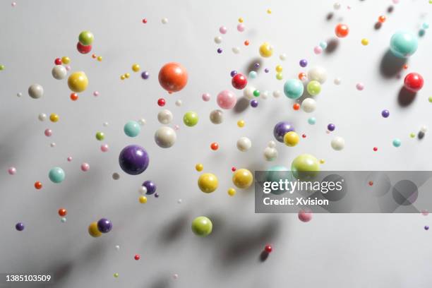 colorful sugar balls flying in mid air in white background - rebound stock pictures, royalty-free photos & images