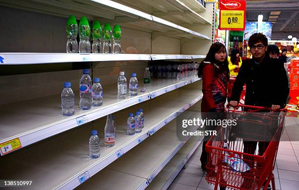 This photo taken on February 8, 2012 shows empty shelves in a supermarket after residents started panic buying mineral water in Nantong, east China's...