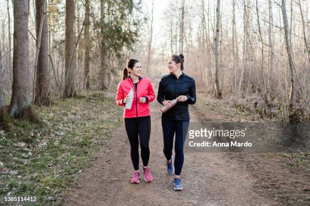 two friends talking and walking after workout. - two woman running fotografías e imágenes de stock