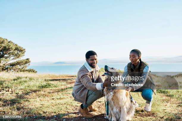 shot of a young couple hiking with their dog out in nature - dog family stock pictures, royalty-free photos & images