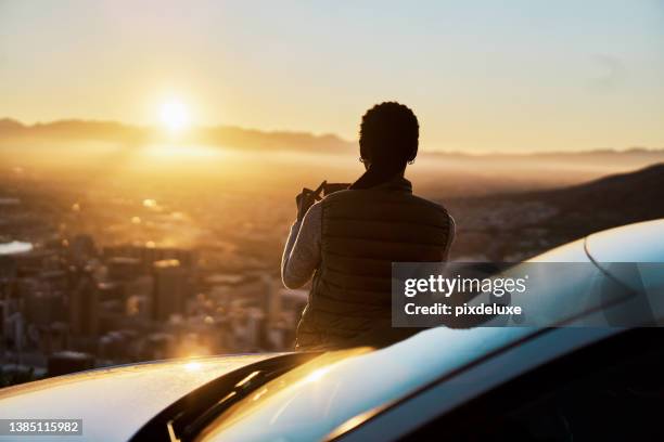 shot of a young woman taking pictures of the view on a road trip - car mountain stock pictures, royalty-free photos & images